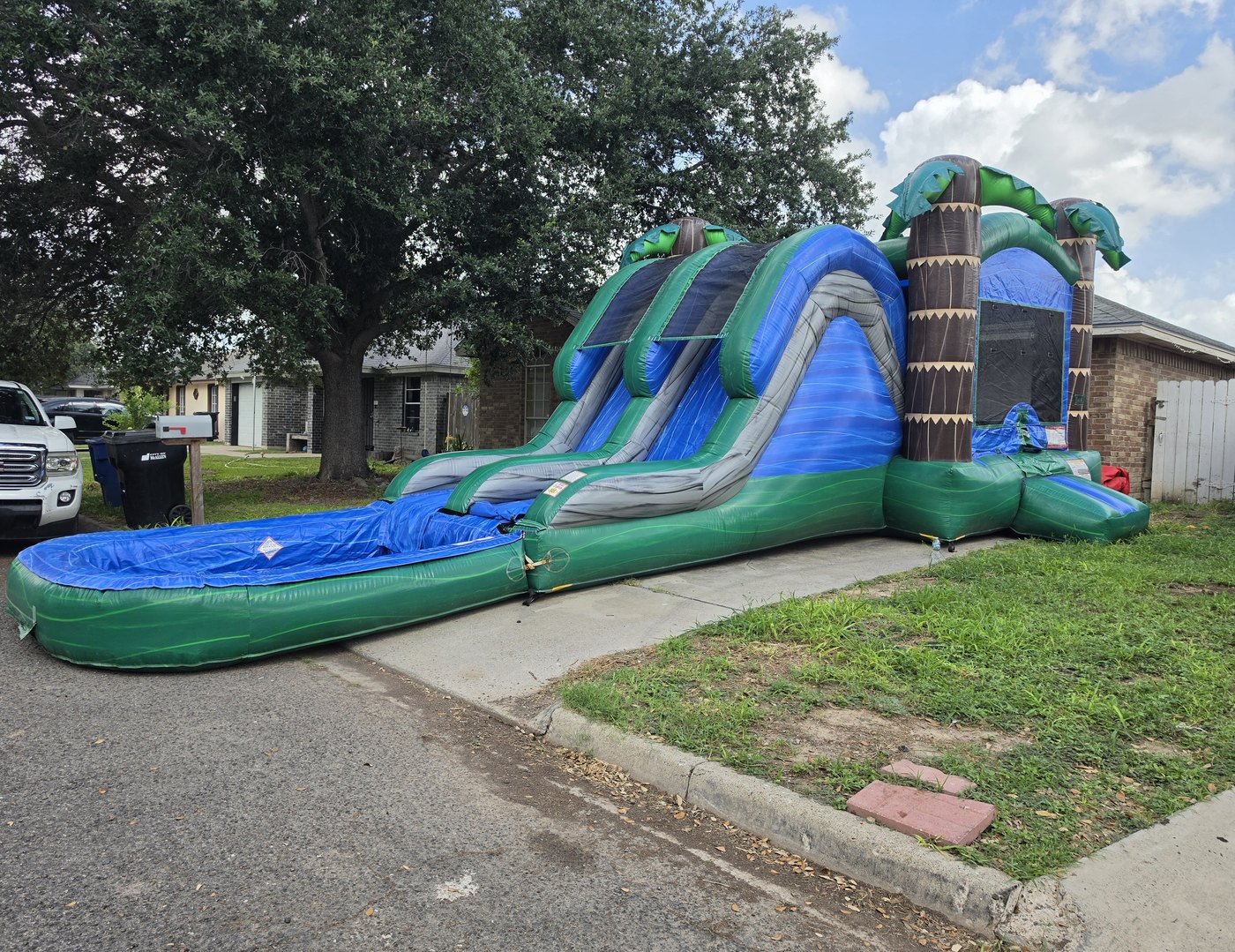 Tropical Blue — combo bounce + dual water slide with palm tree pillars